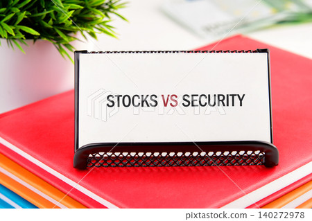 A striking comparison of stocks versus security rests on a stylish holder atop a stack of bright notebooks, framing a scene of financial insight and organization A striking comparison of stocks versus security rests on a stylish holder atop a stack of bright notebooks, framing a scene of financial insight and organization 140272978