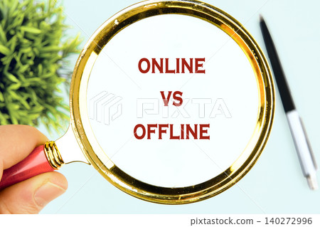 A hand holds a magnifying glass over words reflecting the debate of online versus offline living, highlighting the importance of choosing the right balance for life A hand holds a magnifying glass over words reflecting the debate of online versus offline living, highlighting the importance of choosing the right balance for life 140272996