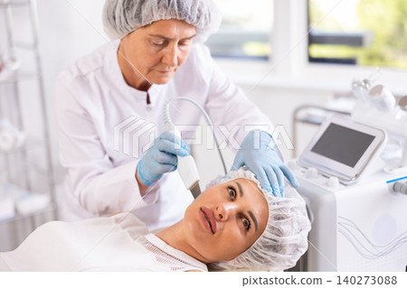 Professional female cosmetologist doing deep cleansing of facial skin of woman in beauty salon Professional female cosmetologist doing deep cleansing of facial skin of woman in beauty salon 140273088