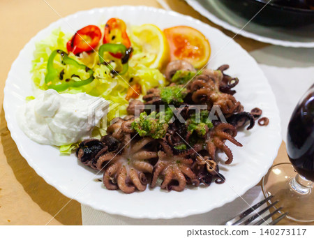 Small fried octopus with sour cream and vegetables Small fried octopus with sour cream and vegetables 140273117