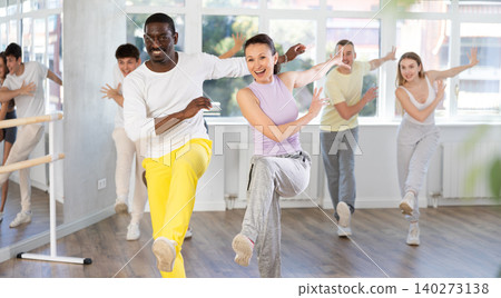 Cheerful biracial practicing vigorous swing in studio Cheerful biracial practicing vigorous swing in studio 140273138