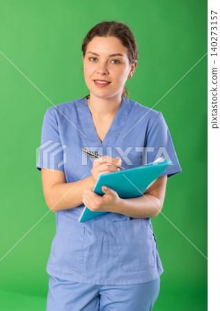 Young woman medic in blue uniform writing medical records Young woman medic in blue uniform writing medical records 140273157