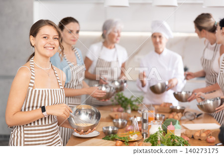 Girl while studying at culinary workshop, cooks appetizing sauce, marinade, dough in bowl Girl while studying at culinary workshop, cooks appetizing sauce, marinade, dough in bowl 140273175