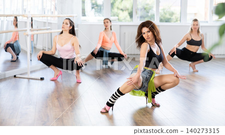 Confident woman leading group heels dance class in studio Confident woman leading group heels dance class in studio 140273315