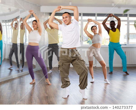 European guy with team of like-minded multinational people learn to elements of waacking dance European guy with team of like-minded multinational people learn to elements of waacking dance 140273377