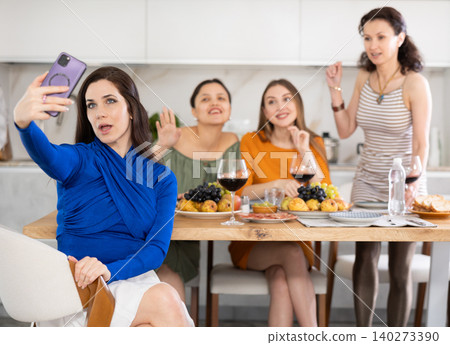 Excited woman taking selfie with besties during home celebration Excited woman taking selfie with besties during home celebration 140273390