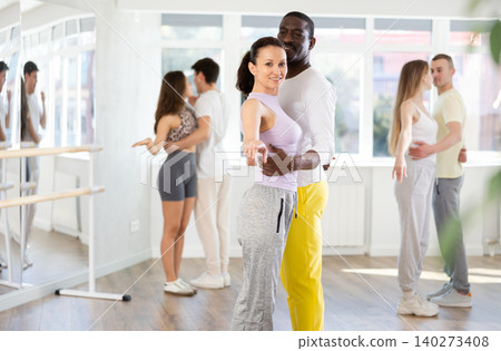 Young man and woman practicing waltz dance in pair in training hall 140273408