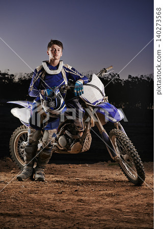 Extreme sport, portrait and man with off road motorcycle, confidence and gear for competition, race or challenge. Adventure, adrenaline and serious face of athlete on course with dirt bike in evening Extreme sport, portrait and man with off road motorcycle, confidence and gear for competition, race or challenge. Adventure, adrenaline and serious face of athlete on course with dirt bike in evening 140273568