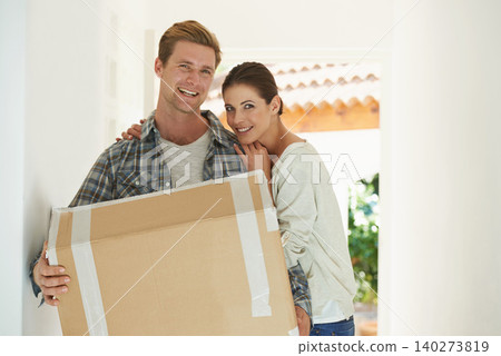 New house, portrait or happy couple with box for moving or excited for investment in real estate. Man, woman and proud homeowner with package by front door and smile face in living room for mortgage New house, portrait or happy couple with box for moving or excited for investment in real estate. Man, woman and proud homeowner with package by front door and smile face in living room for mortgage 140273819