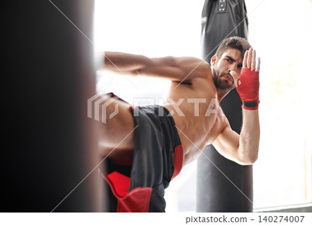 Man, boxing and bag kick for workout class or cardio challenge or fitness practice, training or combat. Athlete, professional and gloves or topless performance in America or gym, strength or sports Man, boxing and bag kick for workout class or cardio challenge or fitness practice, training or combat. Athlete, professional and gloves or topless performance in America or gym, strength or sports 140274007