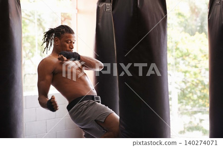 Exercise, body and knee with black man kickboxing in gym for health, power or combat sports training. Fitness, club or self defense and young shirtless fighter with punching bag for strength workout Exercise, body and knee with black man kickboxing in gym for health, power or combat sports training. Fitness, club or self defense and young shirtless fighter with punching bag for strength workout 140274071