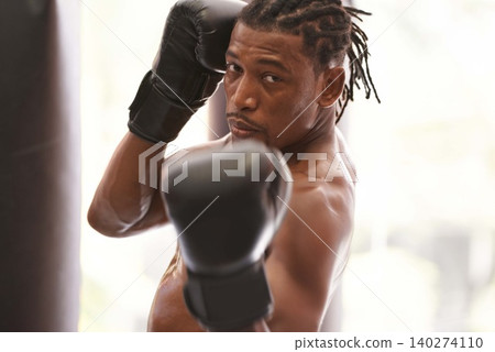 Fitness, portrait and black man with boxing gloves in gym for challenge, fight and competition training. Power, muscle and serious face of champion boxer at workout with confidence in sports club. Fitness, portrait and black man with boxing gloves in gym for challenge, fight and competition training. Power, muscle and serious face of champion boxer at workout with confidence in sports club. 140274110