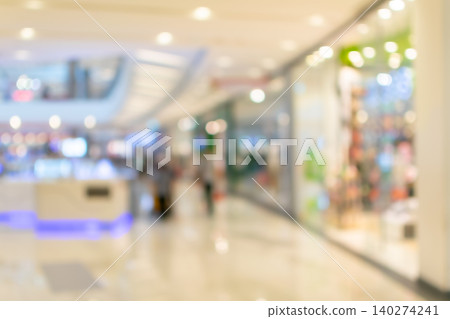 Defocused shopping mall interior bright lights retail storefronts modern architecture creating soft commercial background ample copy space 140274241