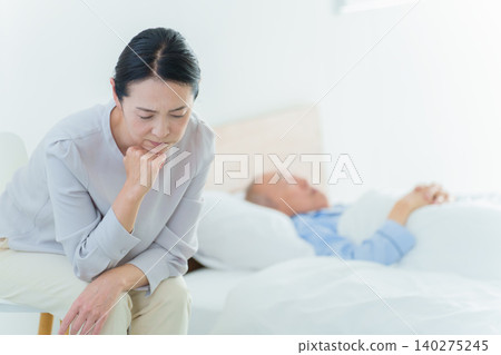 A woman struggling with caring for her elderly parents 140275245