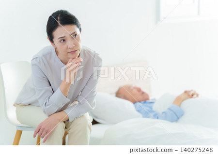 A woman struggling with caring for her elderly parents A woman struggling with caring for her elderly parents 140275248