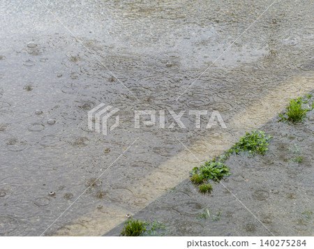 Rain falling on puddles on the road Rain falling on puddles on the road 140275284