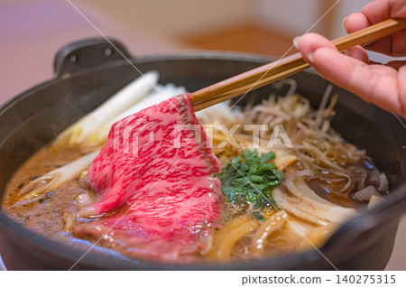 Sukiyaki where you add wagyu beef with chopsticks Sukiyaki where you add wagyu beef with chopsticks 140275315