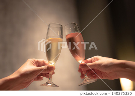 Two glasses toasting under soft lighting 140275320