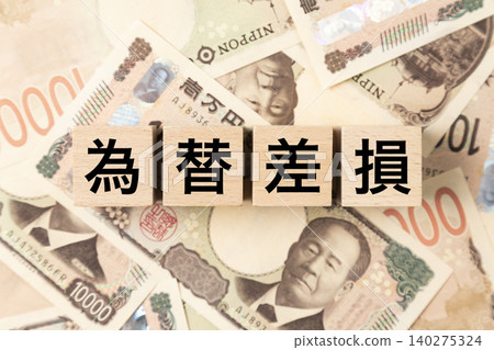 A block with "Exchange Rate Loss" written on it and lots of 10,000 yen bills. A block with "Exchange Rate Loss" written on it and lots of 10,000 yen bills. 140275324
