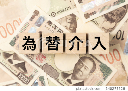 一塊寫著「貨幣幹預」字樣的鈔票和許多10,000日圓面額的鈔票。 140275326