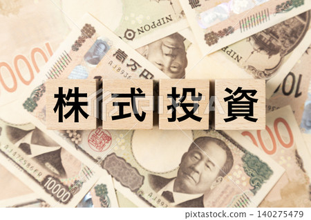 A block with "Stock Investment" written on it and lots of 10,000 yen bills. A block with "Stock Investment" written on it and lots of 10,000 yen bills. 140275479
