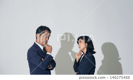 Business professionals, both male and female, who are struggling Business professionals, both male and female, who are struggling 140275488