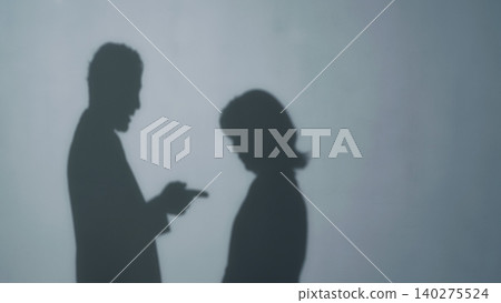 Silhouette of a man warning a woman Silhouette of a man warning a woman 140275524