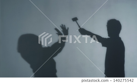 Silhouette of a man raising a hammer at a woman Silhouette of a man raising a hammer at a woman 140275542