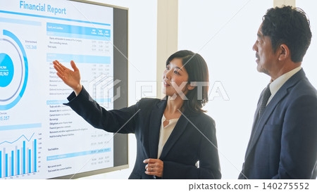 A group of business people holding a meeting while looking at a screen. 140275552