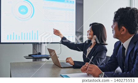 A group of business people holding a meeting while looking at a screen. A group of business people holding a meeting while looking at a screen. 140275553