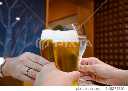 Hands raising a glass in a toast Hands raising a glass in a toast 140275801