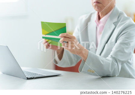 一位老人查看他的銀行存摺；通貨膨脹，物價上漲。 140276225