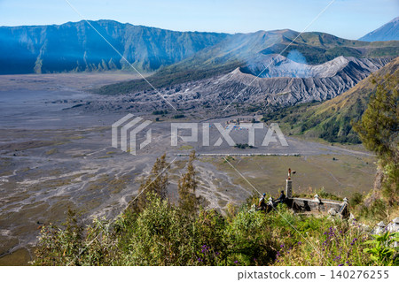 Tourist looking to the crater of Mt.Bromo an active somma volcano in East Java, Indonesia from viewpoint. Tourist looking to the crater of Mt.Bromo an active somma volcano in East Java, Indonesia from viewpoint. 140276255