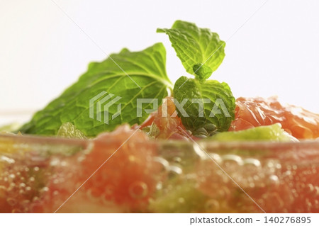 A refreshing sparkling fruit punch with a sprig of mint. 140276895