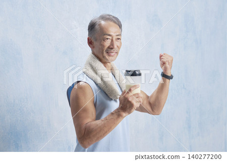 一位老年男子手持蛋白粉瓶進行訓練，並揮拳慶祝。 140277200