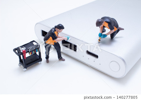 A Miniature technicians repairing electronic device A Miniature technicians repairing electronic device 140277805