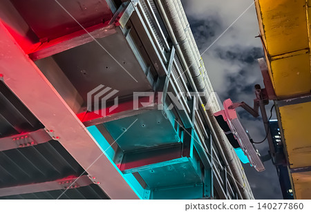 Under the elevated railway at night, traffic lights, cyberpunk-style neon colors, and a dramatic sky. Under the elevated railway at night, traffic lights, cyberpunk-style neon colors, and a dramatic sky. 140277860