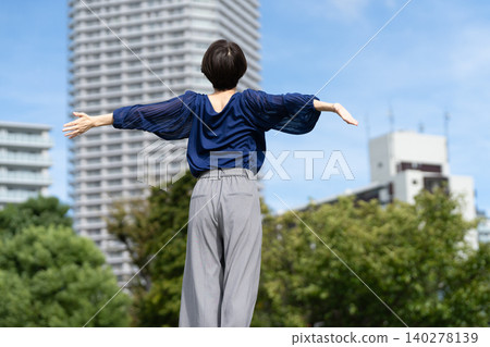 A woman stretching with a cityscape in the background A woman stretching with a cityscape in the background 140278139