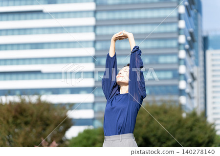 A woman stretching with a cityscape in the background A woman stretching with a cityscape in the background 140278140