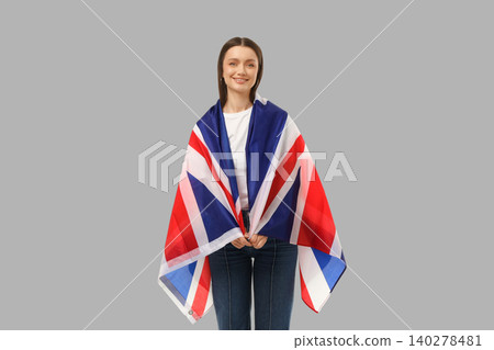 Young woman wraps UK flag around her shoulders Young woman wraps UK flag around her shoulders 140278481