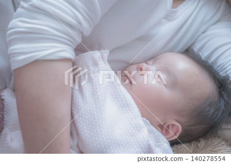 A baby sleeping in someone's arms A baby sleeping in someone's arms 140278554