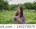 Close-up of a woman eating a rice ball at a picnic. 140278876