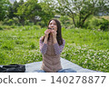 A woman eating rice balls at a picnic. 140278877