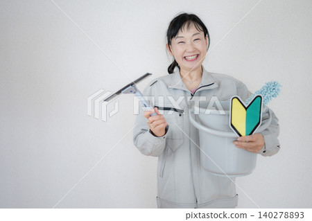 一位面帶微笑的女士手持清潔工具 一位面帶微笑的女士手持清潔工具 140278893