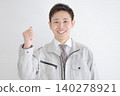一名年輕工人面帶微笑，揮舞著拳頭。 140278921