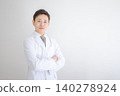 一位身穿白大褂、雙臂交叉的年輕男醫生。 140278924