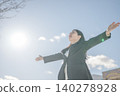 一位女商人張開雙臂，沐浴在藍天之下。 140278928