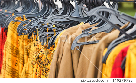 Colorful indian clothes hanging on hangers in a street market in India Colorful indian clothes hanging on hangers in a street market in India 140279783