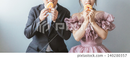 新郎新娘拿著甜甜圈拍婚紗照 新郎新娘拿著甜甜圈拍婚紗照 140280357