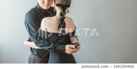 A bride and groom having their pre-wedding photoshoot (proposal, rings) at a studio. A bride and groom having their pre-wedding photoshoot (proposal, rings) at a studio. 140280468